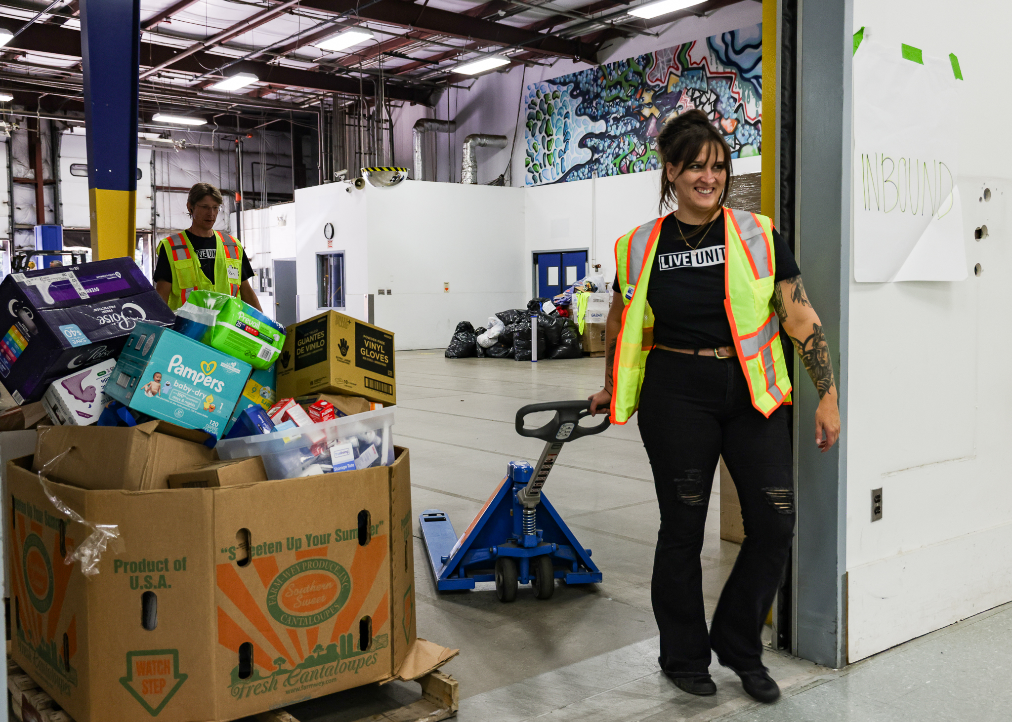 Volunteer moving donation boxes with pallet jack