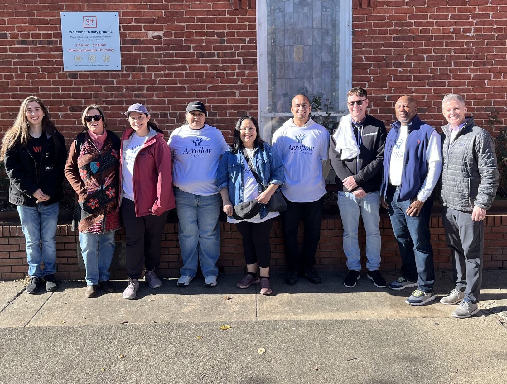 Group standing in front of brick wall