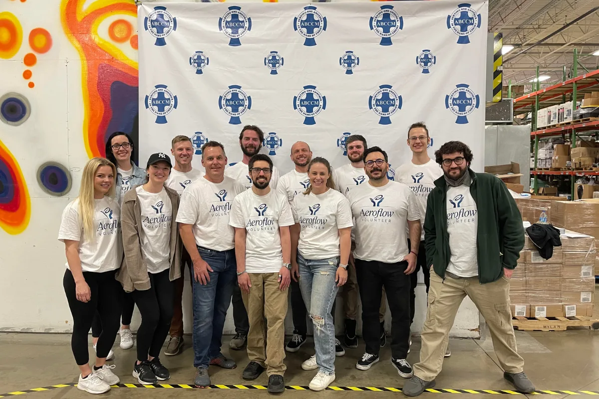 Team posing in front of branded backdrop