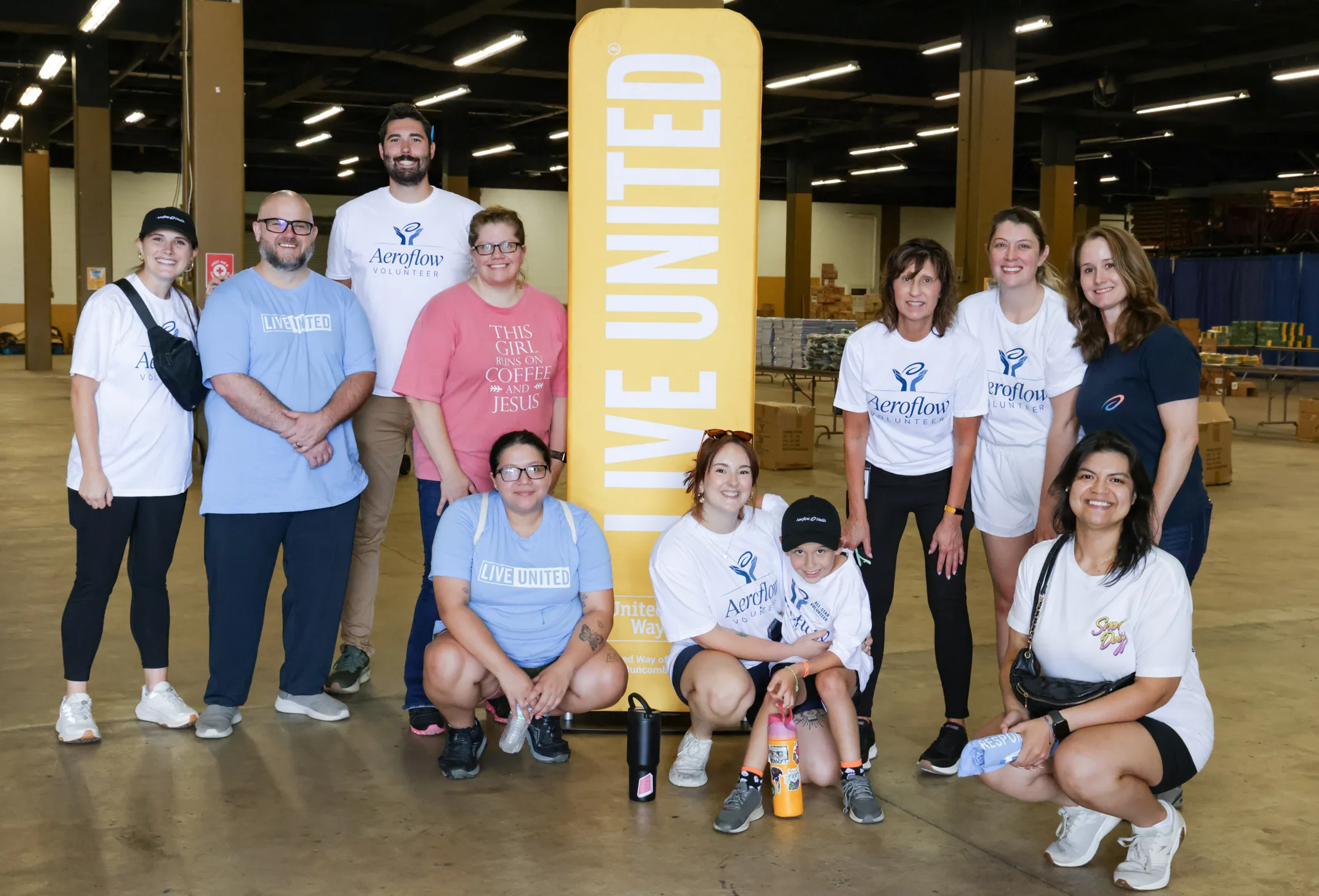 Group standing under “Live United” sign