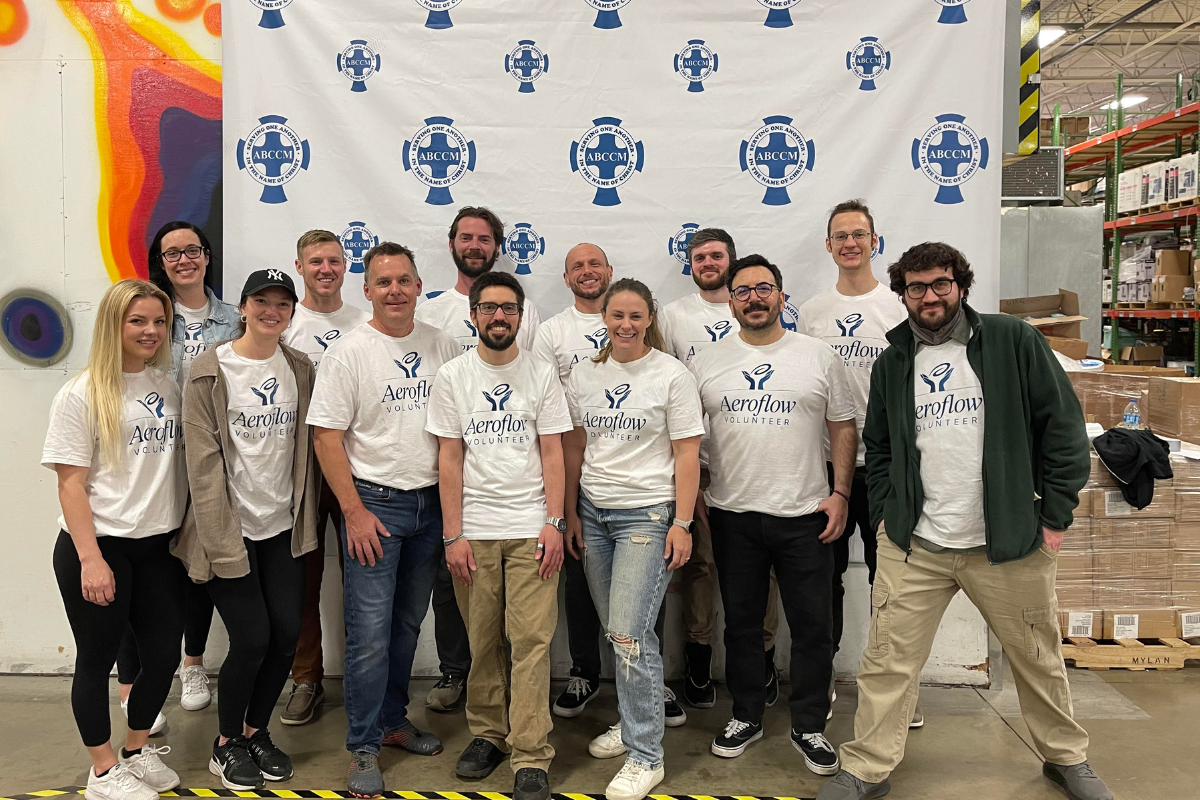 Group posing in front of branded backdrop