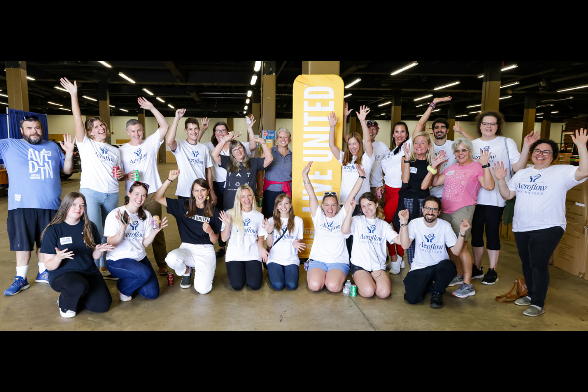 Group posing at event with banner