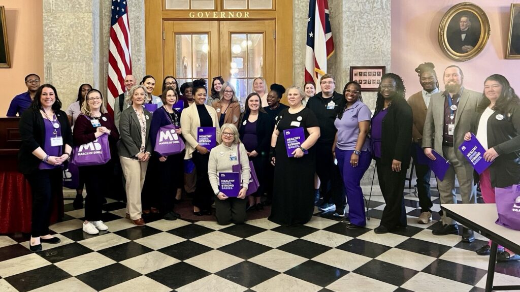 Group posing in formal setting with flags