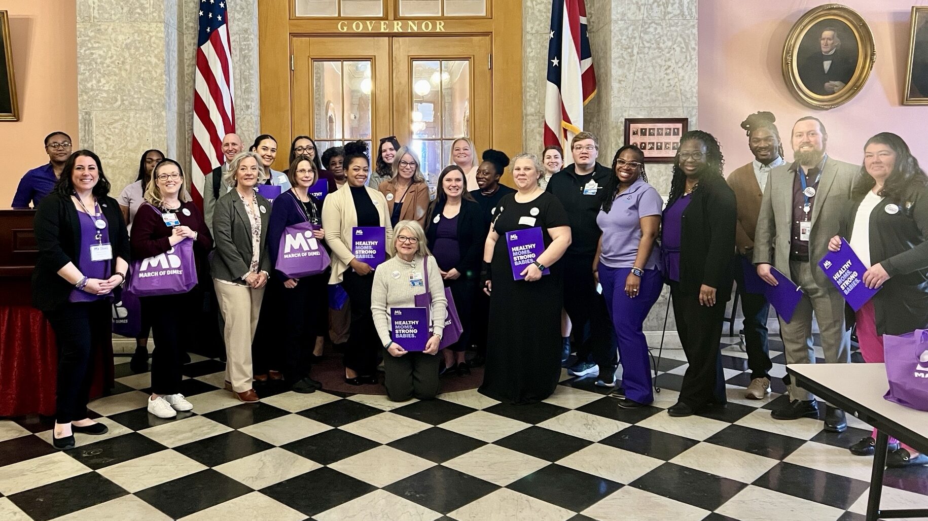 Group posing in formal setting with flags