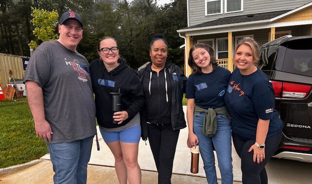Small group posing outside building